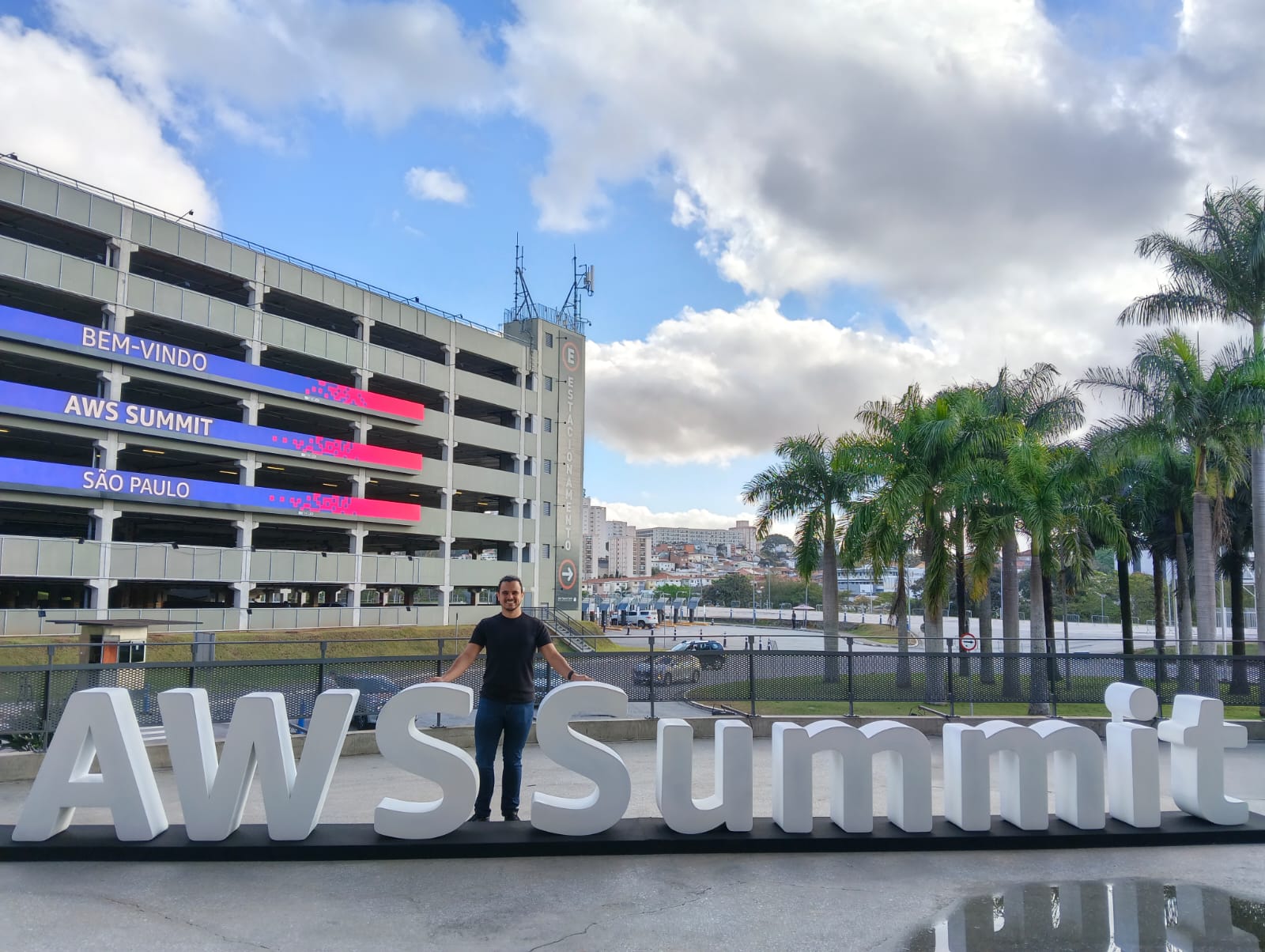 Lucas Lascasas no letreiro do AWS Summit 2026 em São Paulo